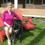 Photo de France Poulin assise à l'extérieur avec son chien-guide Onyx