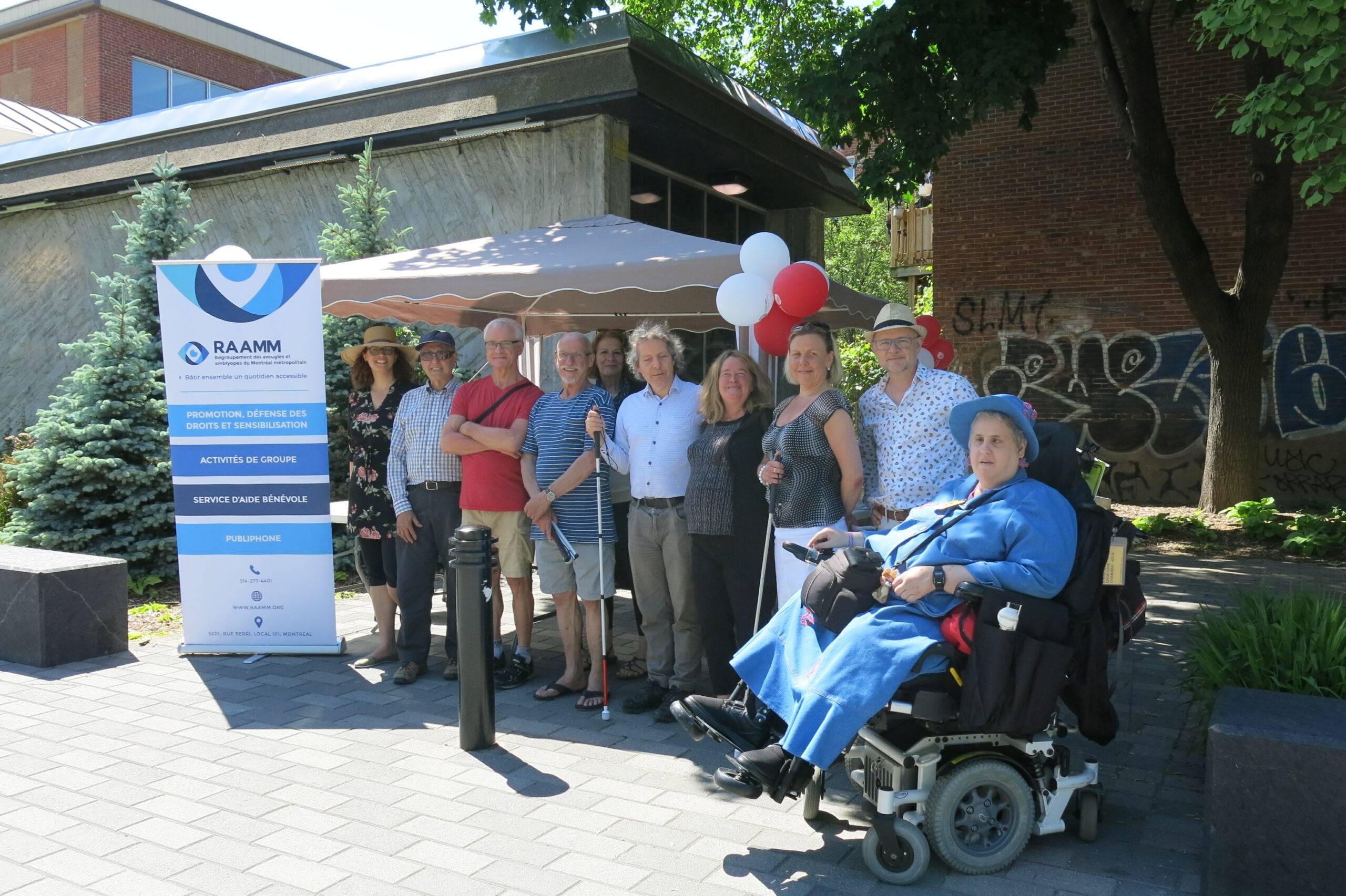 Devenez membre du RAAMM tout comme eux! Photo d'un groupe de membres à un kiosque du RAAMM près de la station Laurier.